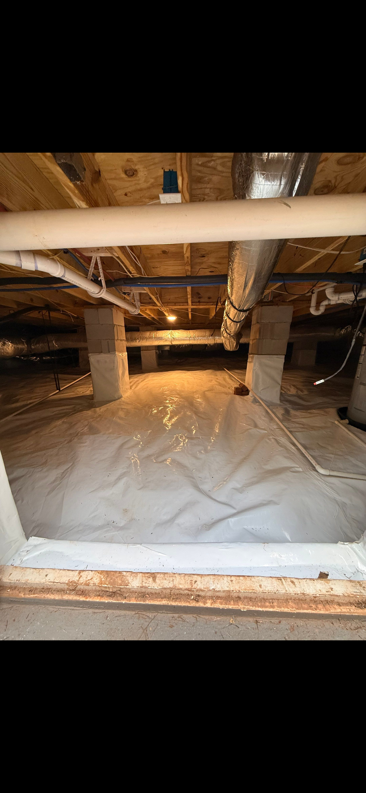 Encapsulated crawlspace with a white ground vapor barrier and wrapped support piers
